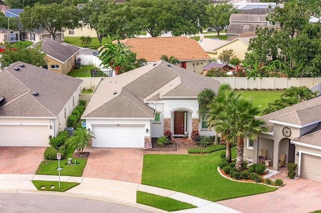 1181 Castlevecchio Loop, Orlando, FL 32825 - view of front facade featuring stucco siding, a residential view, decorative driveway, and an attached garage