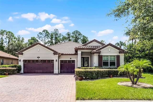 100 Verde Way, Debary, FL 32713 - mediterranean / spanish home with an attached garage, decorative driveway, a front lawn, and stucco siding