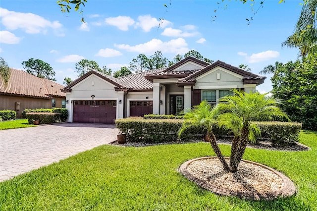 100 Verde Way, Debary, FL 32713 - mediterranean / spanish home with a garage, a front lawn, decorative driveway, a tiled roof, and stucco siding