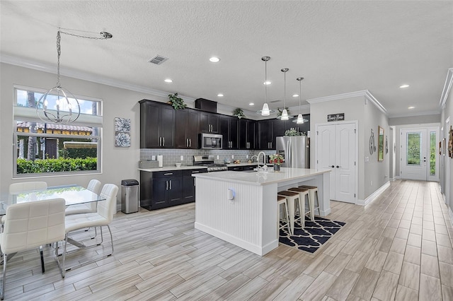100 Verde Way, Debary, FL 32713 - kitchen with stainless steel appliances, light countertops, crown molding, decorative backsplash, and a kitchen bar