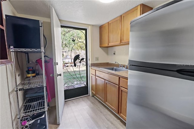 12350 83rd St, Fellsmere, FL 32948 - kitchen featuring freestanding refrigerator, a textured ceiling, and light wood-style floors
