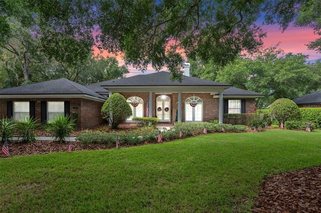 11613 Swift Water Cir, Orlando, FL 32817 - view of front facade with a lawn, brick siding, and a chimney