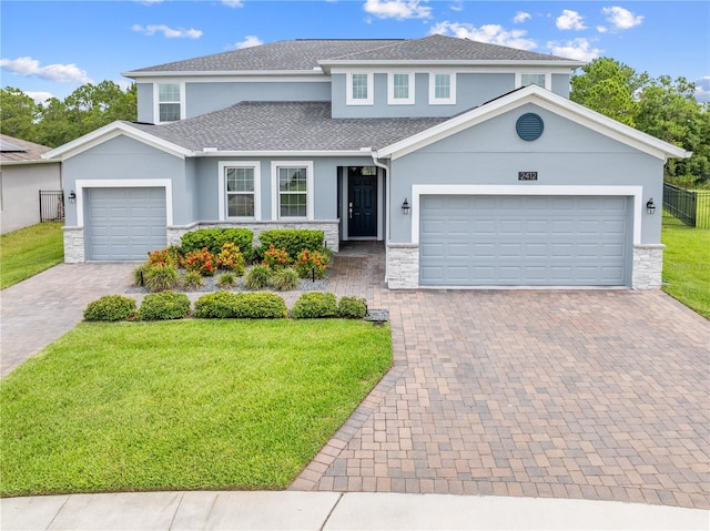 2412 Camden Park Ave, Davenport, FL 33837 - traditional home with stone siding, stucco siding, an attached garage, and decorative driveway