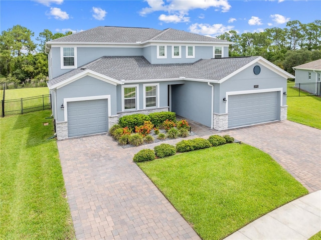 2412 Camden Park Ave, Davenport, FL 33837 - view of front of house featuring an attached garage, decorative driveway, stucco siding, and stone siding