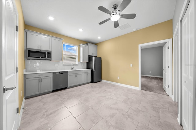 2412 Camden Park Ave, Davenport, FL 33837 - kitchen featuring appliances with stainless steel finishes, gray cabinetry, a ceiling fan, light countertops, and backsplash