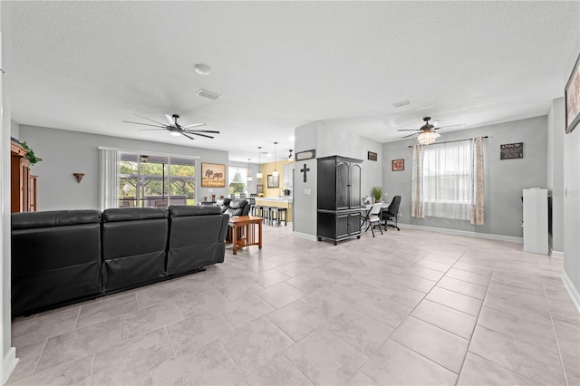 2412 Camden Park Ave, Davenport, FL 33837 - living room with ceiling fan, a textured ceiling, and light tile patterned floors
