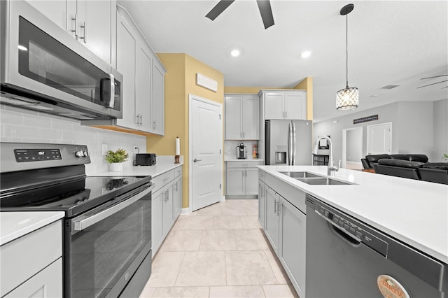 2412 Camden Park Ave, Davenport, FL 33837 - kitchen with stainless steel appliances, a ceiling fan, decorative backsplash, light countertops, and open floor plan
