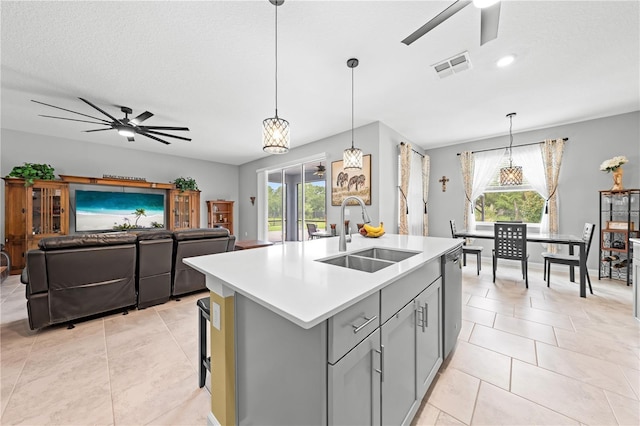 2412 Camden Park Ave, Davenport, FL 33837 - kitchen with a ceiling fan, gray cabinetry, light countertops, an island with sink, and a textured ceiling