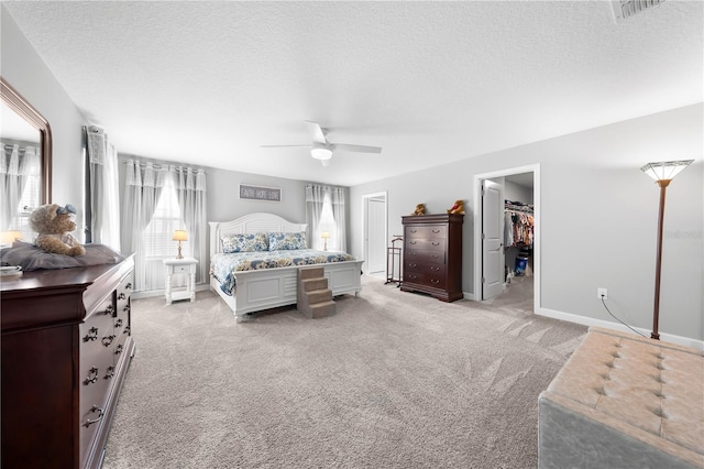 2412 Camden Park Ave, Davenport, FL 33837 - bedroom featuring light carpet, a textured ceiling, a spacious closet, ceiling fan, and a closet