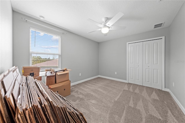 2412 Camden Park Ave, Davenport, FL 33837 - unfurnished bedroom featuring light carpet, a closet, a textured ceiling, and a ceiling fan