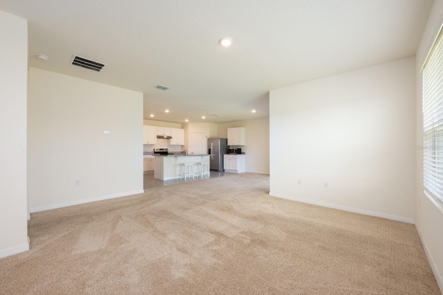 3241 Silas Dr, New Smyrna Beach, FL 32168 - unfurnished living room with light colored carpet and recessed lighting