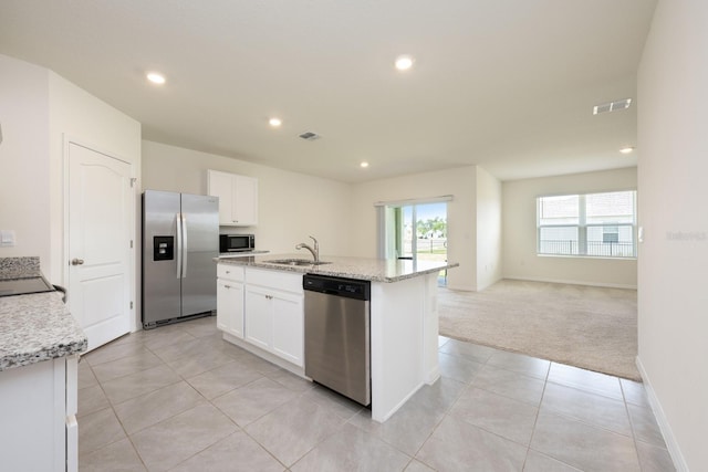 3241 Silas Dr, New Smyrna Beach, FL 32168 - kitchen with appliances with stainless steel finishes, recessed lighting, white cabinetry, open floor plan, and light carpet
