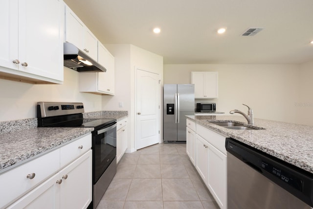 3241 Silas Dr, New Smyrna Beach, FL 32168 - kitchen with appliances with stainless steel finishes, under cabinet range hood, white cabinetry, light stone counters, and recessed lighting