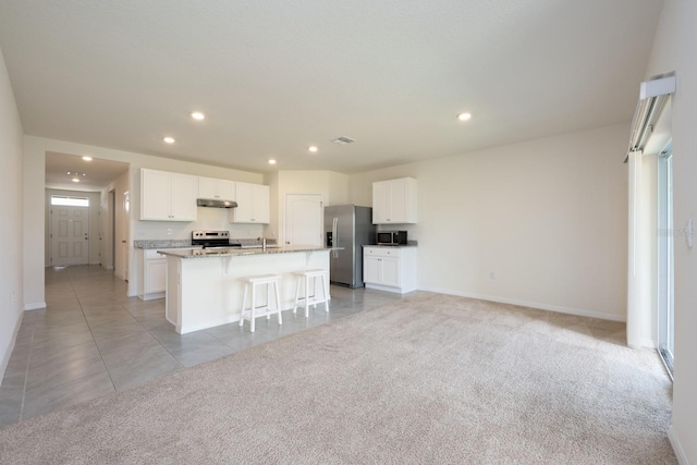3241 Silas Dr, New Smyrna Beach, FL 32168 - kitchen with appliances with stainless steel finishes, a kitchen island with sink, recessed lighting, under cabinet range hood, and white cabinets