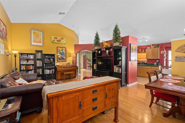 1048 Woodsong Way, Clermont, FL 34714 - living room featuring vaulted ceiling, light wood-style flooring, and arched walkways