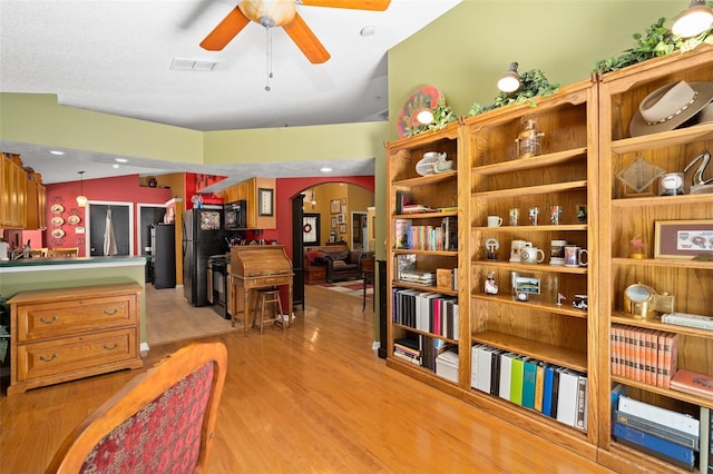 1048 Woodsong Way, Clermont, FL 34714 - sitting room with arched walkways, a ceiling fan, and light wood-style flooring