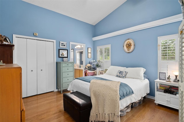 1048 Woodsong Way, Clermont, FL 34714 - bedroom with high vaulted ceiling, wood finished floors, multiple windows, and a closet
