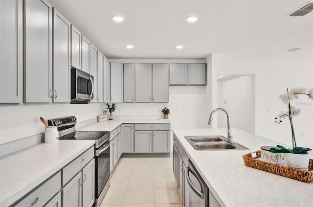 554 Pawnee Ct, Haines City, FL 33844 - kitchen with appliances with stainless steel finishes, gray cabinets, light countertops, light tile patterned floors, and recessed lighting