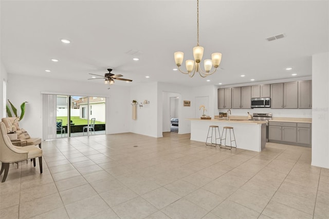 554 Pawnee Ct, Haines City, FL 33844 - kitchen with appliances with stainless steel finishes, gray cabinets, open floor plan, recessed lighting, and a chandelier