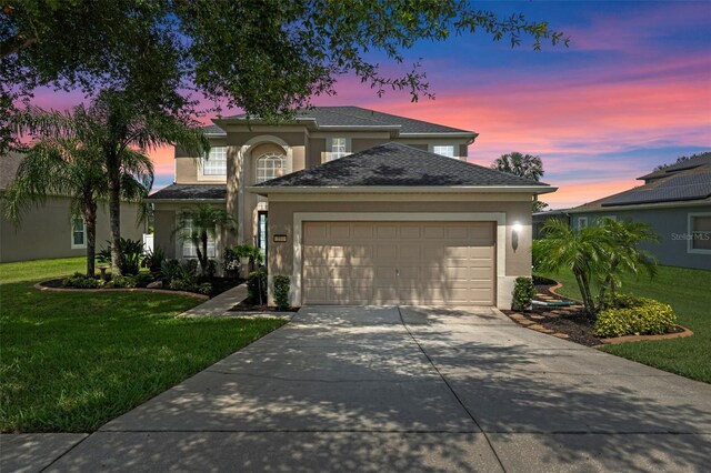 594 Hernando Pl, Clermont, FL 34715 - traditional-style house with stucco siding, concrete driveway, a garage, and a yard