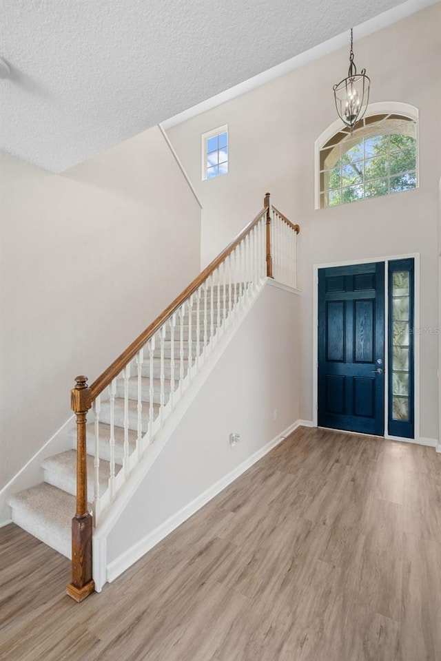 594 Hernando Pl, Clermont, FL 34715 - entryway with wood finished floors, stairs, a chandelier, a textured ceiling, and a towering ceiling