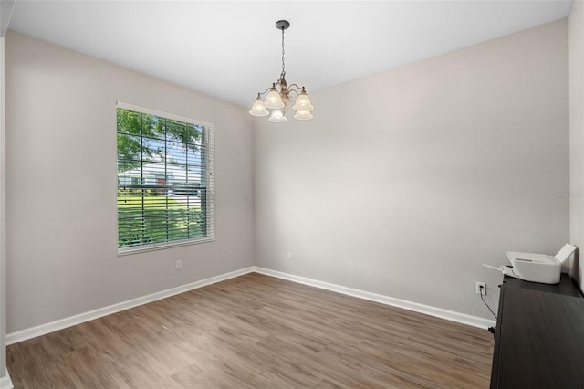 594 Hernando Pl, Clermont, FL 34715 - spare room with wood finished floors and a chandelier