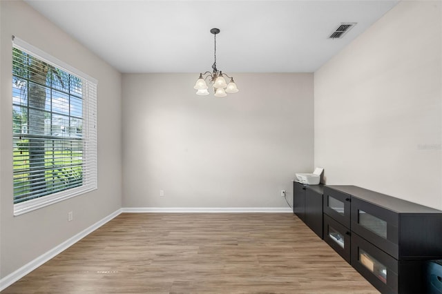 594 Hernando Pl, Clermont, FL 34715 - unfurnished dining area featuring plenty of natural light, a chandelier, and light wood finished floors
