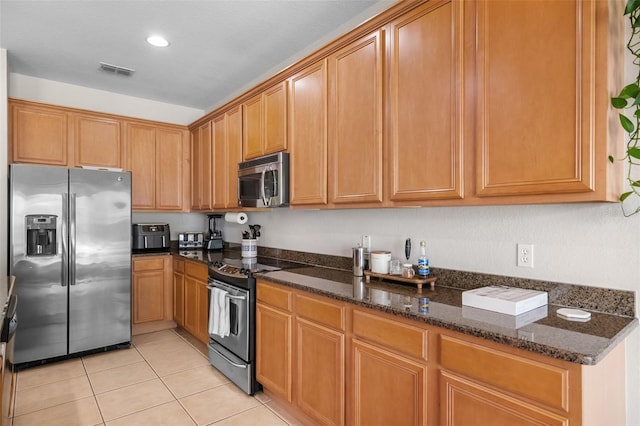 594 Hernando Pl, Clermont, FL 34715 - kitchen with appliances with stainless steel finishes, light tile patterned flooring, dark stone counters, and recessed lighting