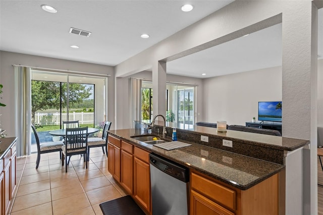 594 Hernando Pl, Clermont, FL 34715 - kitchen with stainless steel dishwasher, dark stone counters, healthy amount of natural light, brown cabinets, and recessed lighting