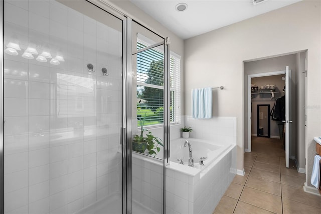594 Hernando Pl, Clermont, FL 34715 - bathroom featuring a stall shower, tile patterned flooring, a bath, and a spacious closet