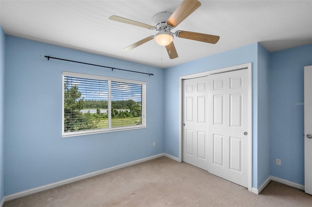 594 Hernando Pl, Clermont, FL 34715 - unfurnished bedroom featuring light carpet, a closet, and ceiling fan