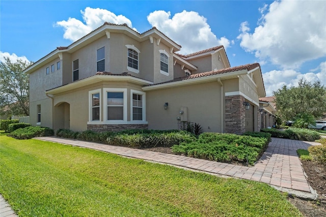 2122 Bent Grass Ave, Ocoee, FL 34761 - view of side of home featuring stone siding, stucco siding, a lawn, and a tile roof