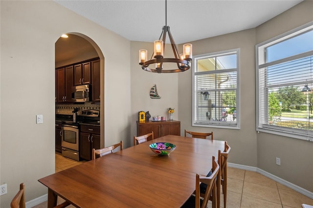 2122 Bent Grass Ave, Ocoee, FL 34761 - dining area with arched walkways, plenty of natural light, a chandelier, and light tile patterned flooring