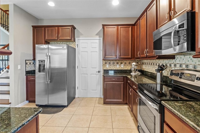 2122 Bent Grass Ave, Ocoee, FL 34761 - kitchen featuring appliances with stainless steel finishes, dark stone countertops, tasteful backsplash, light tile patterned floors, and recessed lighting