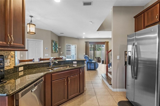 2122 Bent Grass Ave, Ocoee, FL 34761 - kitchen featuring appliances with stainless steel finishes, light tile patterned flooring, dark stone countertops, a peninsula, and recessed lighting