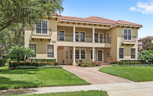 8424 Lake Burden Cir, Windermere, FL 34786 - mediterranean / spanish-style house featuring a balcony, stucco siding, a front lawn, and a tiled roof