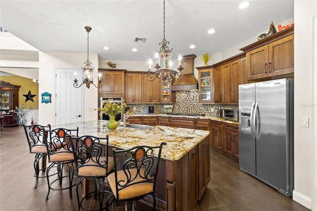8424 Lake Burden Cir, Windermere, FL 34786 - kitchen featuring appliances with stainless steel finishes, a chandelier, brown cabinetry, backsplash, and recessed lighting