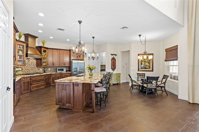 8424 Lake Burden Cir, Windermere, FL 34786 - kitchen featuring custom exhaust hood, stainless steel refrigerator with ice dispenser, a chandelier, tasteful backsplash, and recessed lighting
