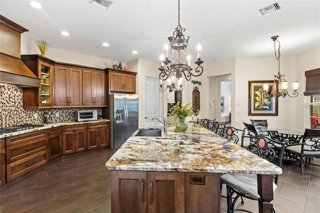 8424 Lake Burden Cir, Windermere, FL 34786 - kitchen featuring stainless steel appliances, a chandelier, premium range hood, decorative backsplash, and a breakfast bar area