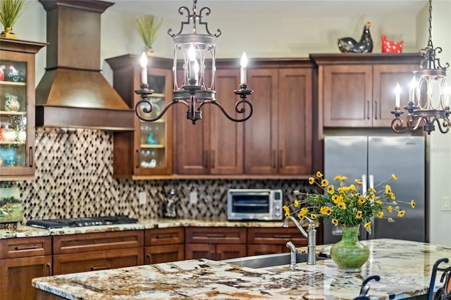 8424 Lake Burden Cir, Windermere, FL 34786 - kitchen with a chandelier, custom exhaust hood, stainless steel appliances, hanging light fixtures, and glass insert cabinets
