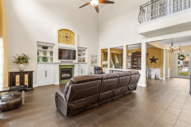 8424 Lake Burden Cir, Windermere, FL 34786 - living area featuring ceiling fan, a chandelier, a towering ceiling, and a glass covered fireplace