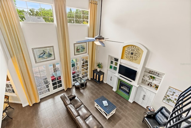 8424 Lake Burden Cir, Windermere, FL 34786 - living room with dark wood-style flooring, ceiling fan, a glass covered fireplace, and french doors