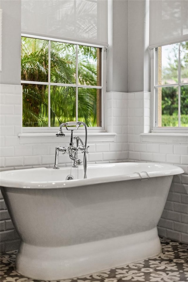 8424 Lake Burden Cir, Windermere, FL 34786 - bathroom featuring tile walls, a soaking tub, and a wainscoted wall