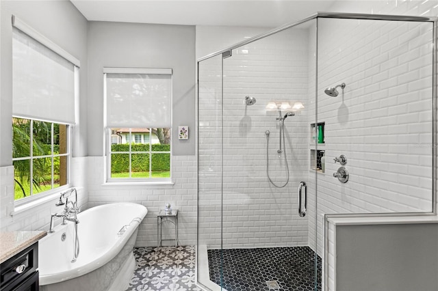 8424 Lake Burden Cir, Windermere, FL 34786 - full bathroom with a soaking tub, a stall shower, wainscoting, tile walls, and vanity