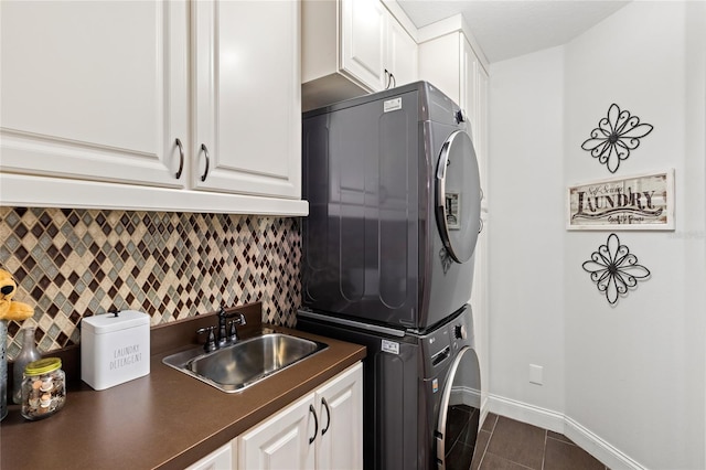 8424 Lake Burden Cir, Windermere, FL 34786 - laundry area with stacked washer / dryer, cabinet space, and dark tile patterned floors