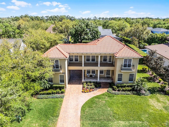 8424 Lake Burden Cir, Windermere, FL 34786 - mediterranean / spanish-style home featuring a tiled roof, stucco siding, a front lawn, and covered porch