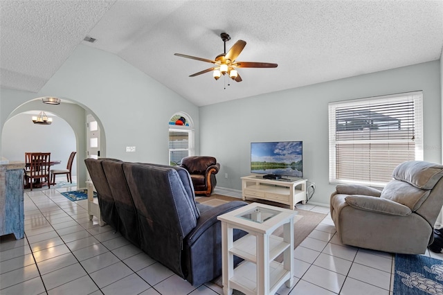 851 Bates Ct, Casselberry, FL 32707 - living area featuring arched walkways, vaulted ceiling, ceiling fan, a textured ceiling, and light tile patterned floors