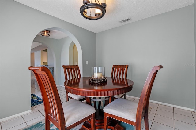851 Bates Ct, Casselberry, FL 32707 - dining space featuring tile patterned flooring, arched walkways, and a textured ceiling