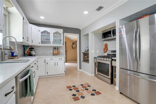 1035 Paladin Ct, Orlando, FL 32812 - kitchen featuring stainless steel appliances, tasteful backsplash, ornamental molding, white cabinets, and glass insert cabinets