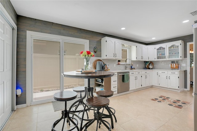 1035 Paladin Ct, Orlando, FL 32812 - kitchen with dishwasher, light countertops, light tile patterned floors, white cabinetry, and backsplash
